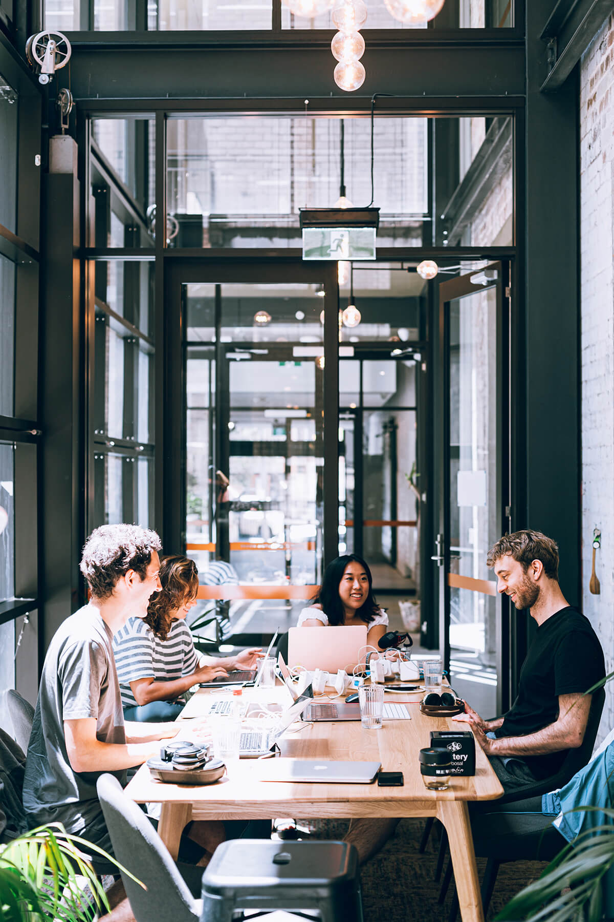 Group of people working together while sitting at a table.